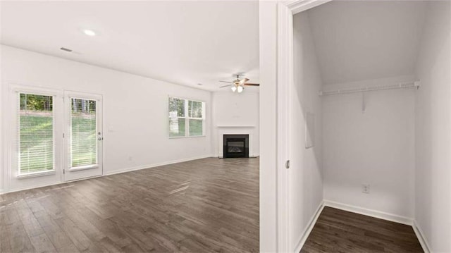 unfurnished living room with dark hardwood / wood-style flooring, plenty of natural light, and ceiling fan