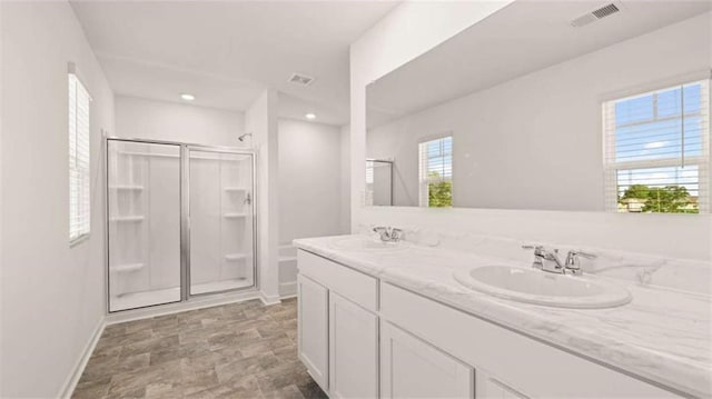 bathroom featuring vanity, a healthy amount of sunlight, and an enclosed shower