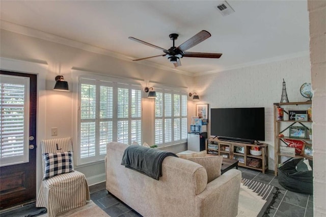 tiled living room with ceiling fan and crown molding