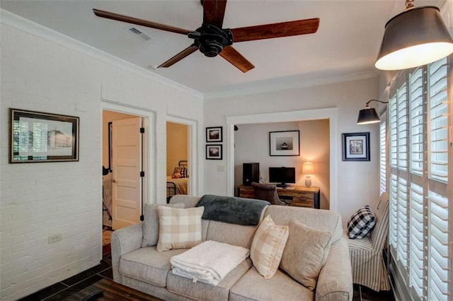 living room featuring ceiling fan, dark hardwood / wood-style flooring, ornamental molding, and brick wall