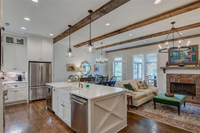 kitchen with white cabinets, appliances with stainless steel finishes, and hanging light fixtures