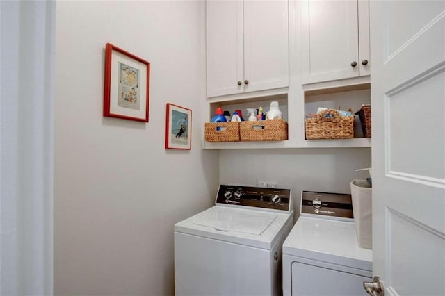 laundry area featuring washing machine and dryer and cabinets