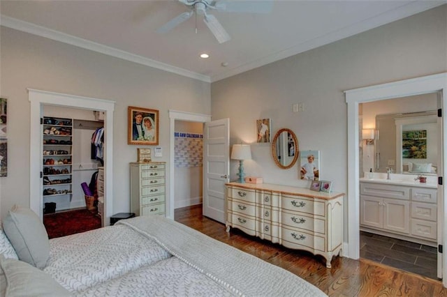 bedroom with a walk in closet, dark hardwood / wood-style flooring, ceiling fan, connected bathroom, and a closet