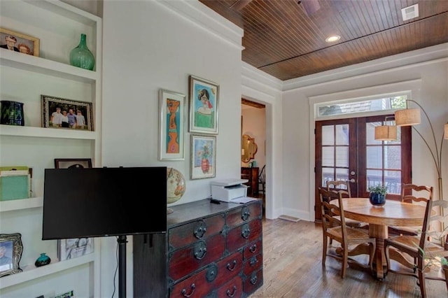 dining room featuring french doors, a healthy amount of sunlight, built in features, wood-type flooring, and wood ceiling