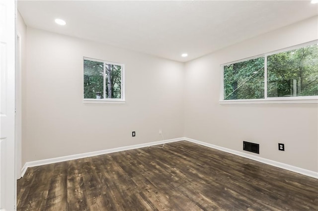 spare room featuring dark wood-style floors, baseboards, and recessed lighting