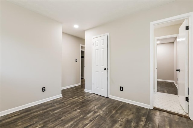 unfurnished bedroom with dark wood-style floors, baseboards, recessed lighting, and a closet