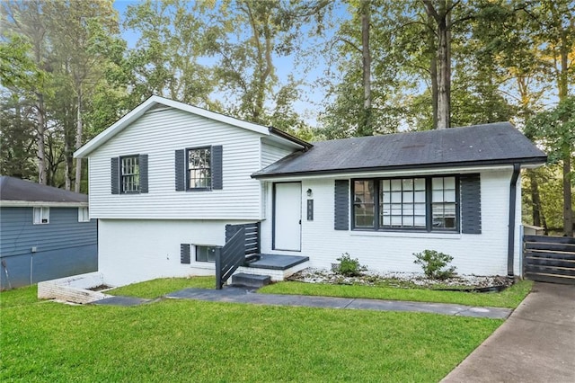 split level home with a front lawn and brick siding
