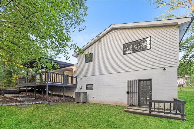 rear view of property featuring a deck, a lawn, and cooling unit