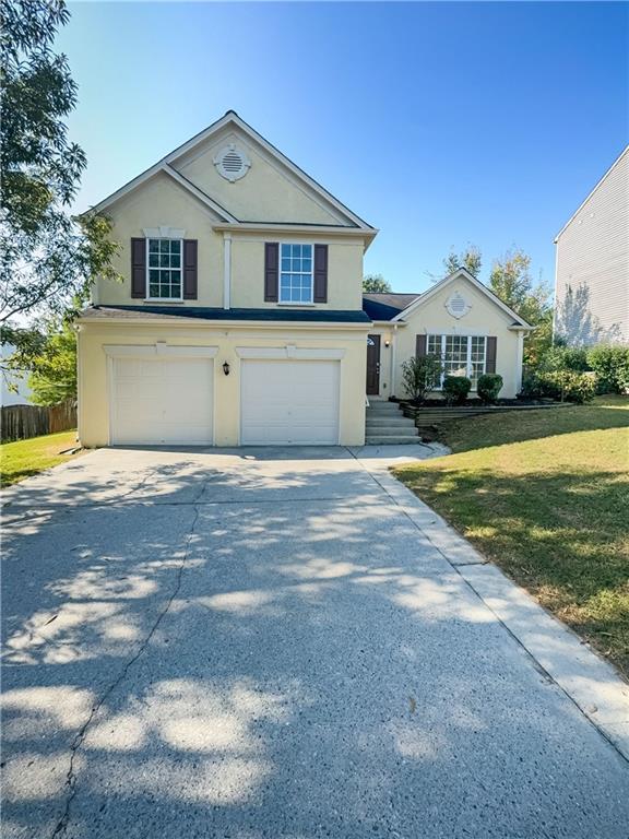 front facade with a garage and a front yard