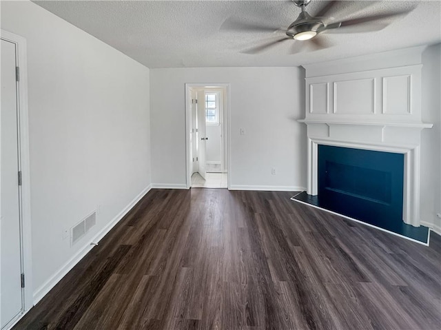 unfurnished living room with a textured ceiling, ceiling fan, and dark hardwood / wood-style floors