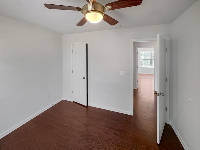 unfurnished bedroom with dark wood-type flooring and ceiling fan