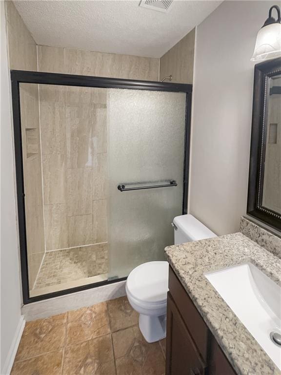 bathroom featuring a textured ceiling, a shower with shower door, vanity, toilet, and tile patterned floors