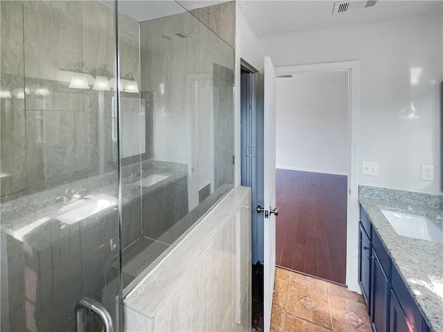 bathroom with tile patterned flooring, a shower with door, and vanity