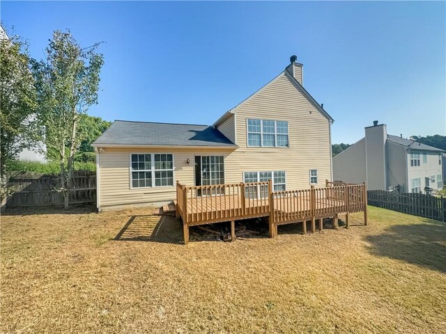 rear view of property with a yard and a deck