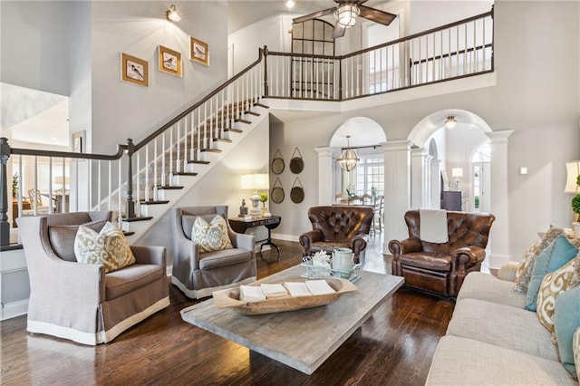 8625 Anchor On Lanier Ct, Gainesville, GA 30506 - living area featuring arched walkways, a towering ceiling, decorative columns, wood finished floors, and stairway