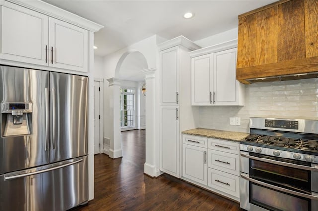 8625 Anchor On Lanier Ct, Gainesville, GA 30506 - kitchen featuring appliances with stainless steel finishes, decorative columns, arched walkways, decorative backsplash, and white cabinets