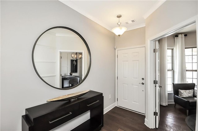 foyer entrance featuring ornamental molding and dark wood-type flooring