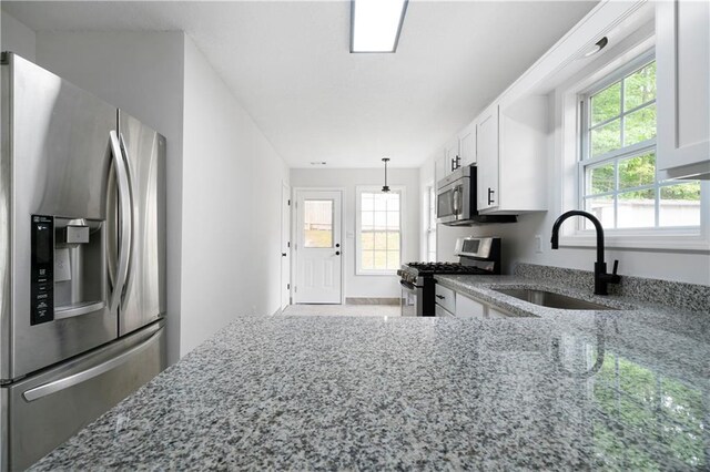 1031 Abercorn Way, Douglasville, GA 30134 - kitchen with a wealth of natural light, light stone counters, appliances with stainless steel finishes, and a sink