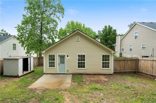 1031 Abercorn Way, Douglasville, GA 30134 - rear view of house featuring a storage unit, a fenced backyard, an outbuilding, and a patio area