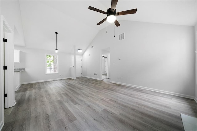 1031 Abercorn Way, Douglasville, GA 30134 - unfurnished living room featuring ceiling fan, high vaulted ceiling, visible vents, baseboards, and wood finished floors