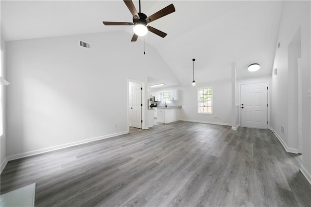 1031 Abercorn Way, Douglasville, GA 30134 - unfurnished living room featuring wood finished floors, baseboards, visible vents, a ceiling fan, and high vaulted ceiling