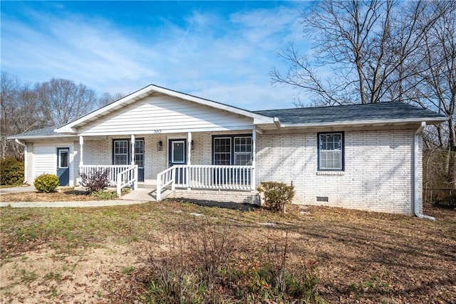 ranch-style home featuring covered porch and a front lawn