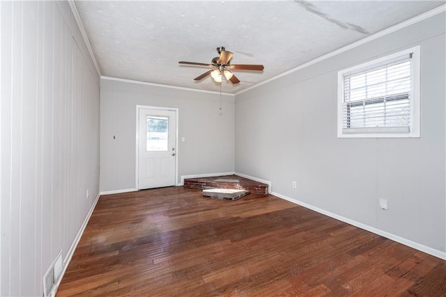 spare room with ceiling fan, ornamental molding, and dark hardwood / wood-style flooring