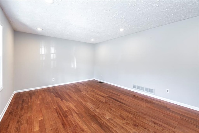 empty room featuring hardwood / wood-style flooring and a textured ceiling