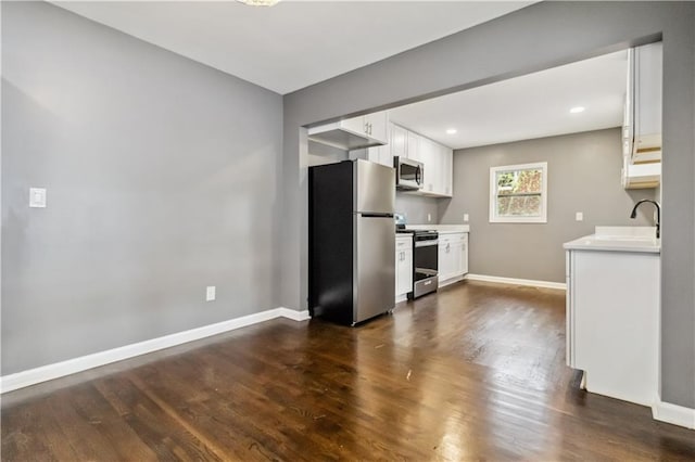 2267 Bryant Dr, East Point, GA 30344 - kitchen with light countertops, dark wood finished floors, appliances with stainless steel finishes, and white cabinets