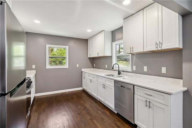 2267 Bryant Dr, East Point, GA 30344 - kitchen with a sink, dark wood finished floors, stainless steel appliances, baseboards, and white cabinetry