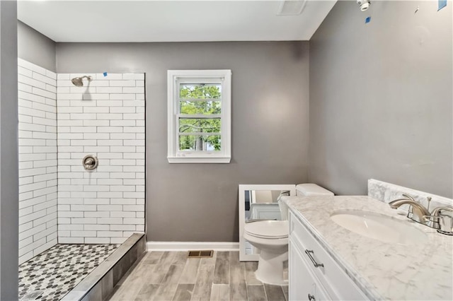 2267 Bryant Dr, East Point, GA 30344 - bathroom with a tile shower, vanity, toilet, baseboards, and visible vents