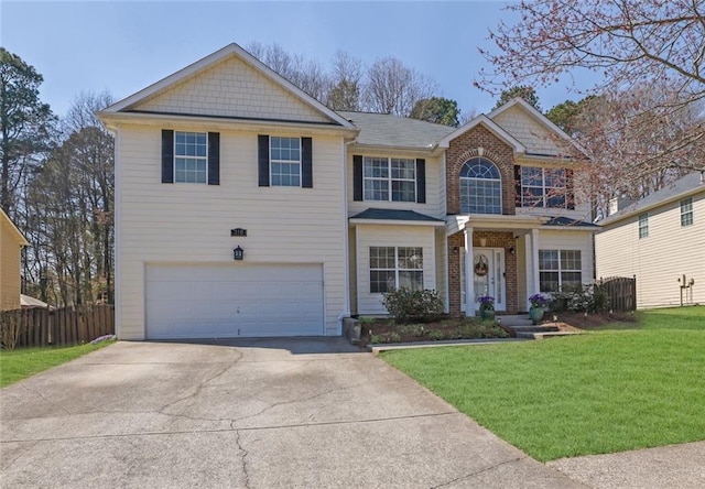 view of front facade with brick siding, a front lawn, fence, concrete driveway, and a garage