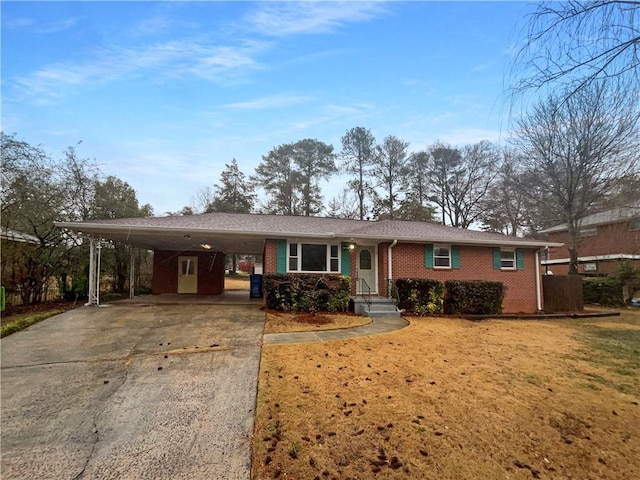 ranch-style house with an attached carport, concrete driveway, and brick siding