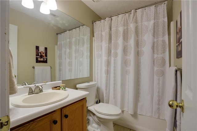 full bath with a textured ceiling, vanity, and toilet