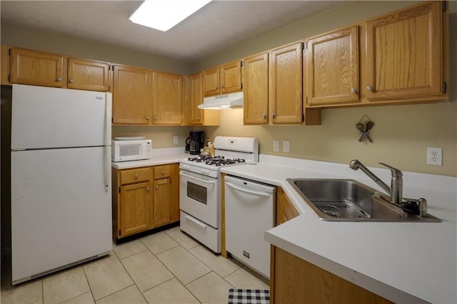 kitchen with white appliances, light countertops, under cabinet range hood, a sink, and light tile patterned flooring