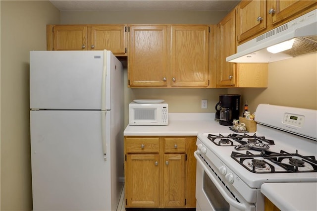 kitchen with white appliances, light countertops, and under cabinet range hood