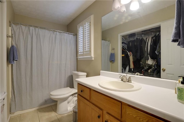 bathroom featuring a textured ceiling, vanity, toilet, and tile patterned floors