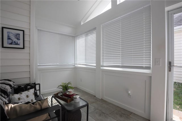 sitting room featuring a wealth of natural light, lofted ceiling, and light tile patterned floors