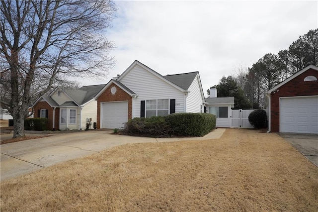 view of front facade featuring a garage, a gate, brick siding, and driveway