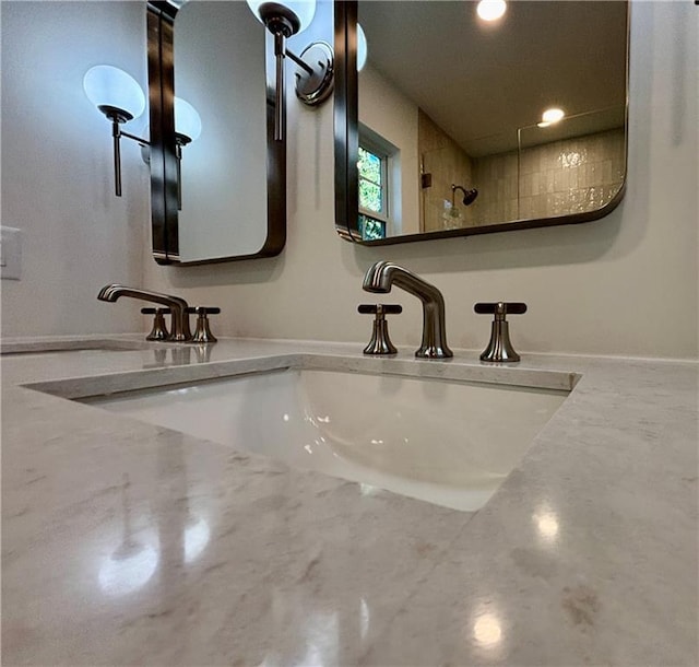 interior details with double vanity, recessed lighting, and a sink