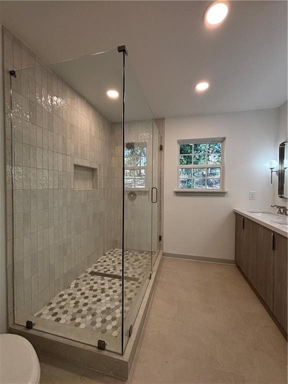 full bath with vanity, recessed lighting, baseboards, and a stall shower