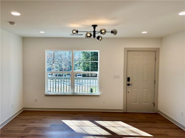 foyer with recessed lighting, baseboards, an inviting chandelier, and wood finished floors