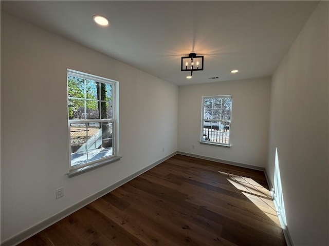 unfurnished dining area featuring an inviting chandelier, recessed lighting, wood finished floors, and baseboards