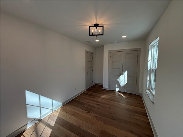 foyer entrance with baseboards, visible vents, dark wood finished floors, an inviting chandelier, and recessed lighting