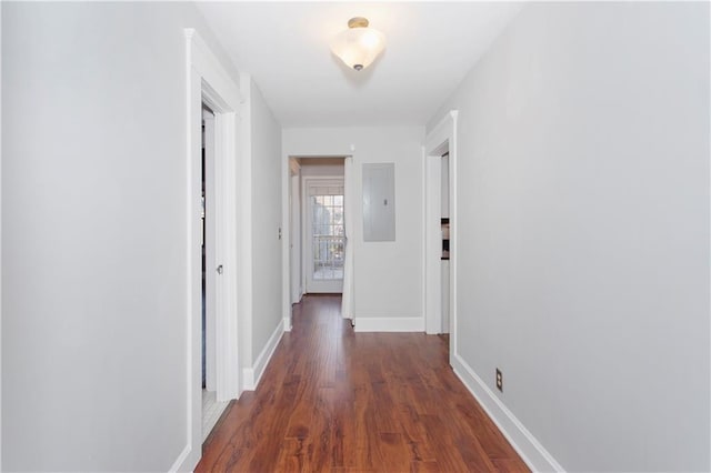 corridor featuring baseboards, dark wood-style floors, and electric panel