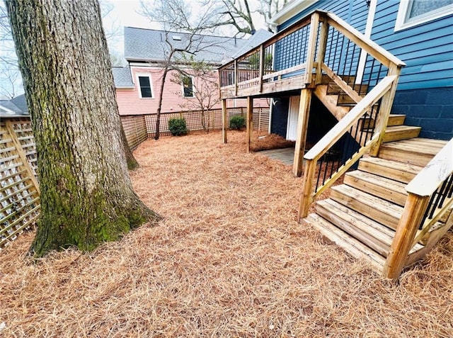 view of yard featuring a fenced backyard, stairs, and a deck