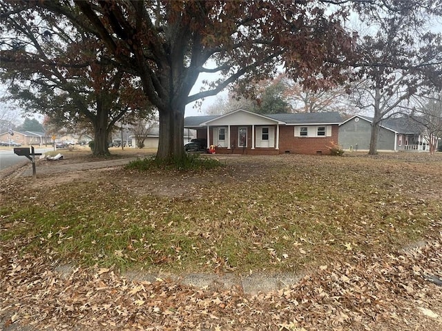 view of front of property featuring covered porch, crawl space, and brick siding