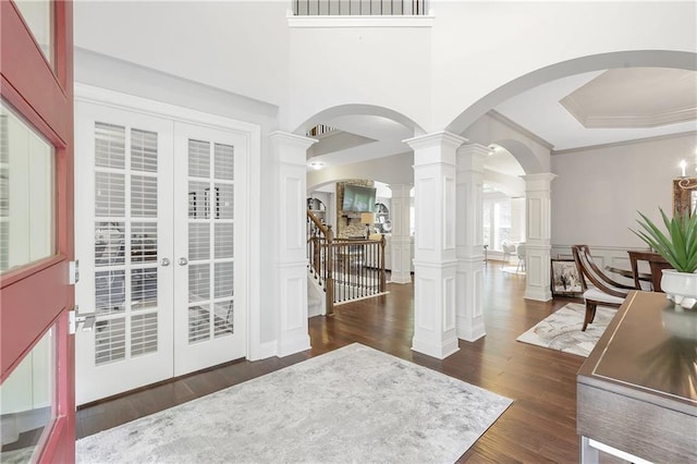 1546 Heritage Pass, Milton, GA 30004 - entryway featuring dark wood-style floors, ornate columns, crown molding, a tray ceiling, and arched walkways