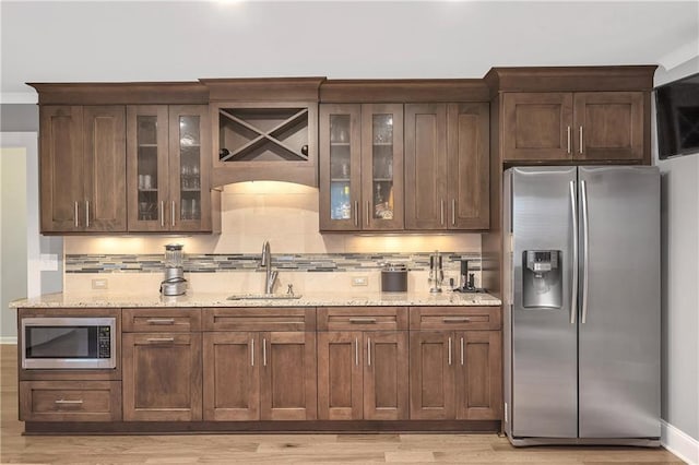 1546 Heritage Pass, Milton, GA 30004 - kitchen featuring stainless steel appliances, a sink, light wood finished floors, backsplash, and light stone countertops
