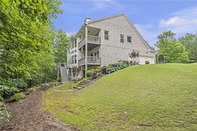 1546 Heritage Pass, Milton, GA 30004 - back of house featuring a balcony, stairway, a lawn, a chimney, and brick siding